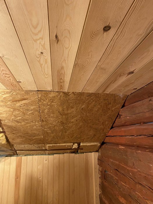 Trätak under renovering där nyplanhyvlade brädor ersätter en OSB-skiva.