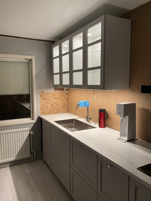 Ej färdigställd köksrenovering med provisorisk fläkt och inkopplad belysning.