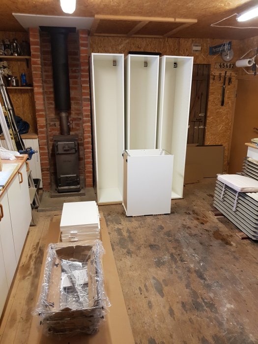 Nybyggda vita skåpstommar och nyligen målade lister i en verkstad.