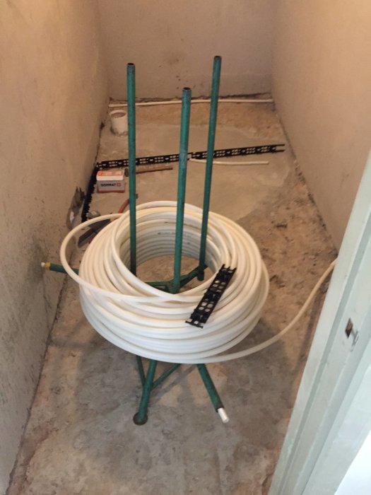 Kabel på rulle monterad på ett stativ i ett ofärdigt utrymme under renovering.