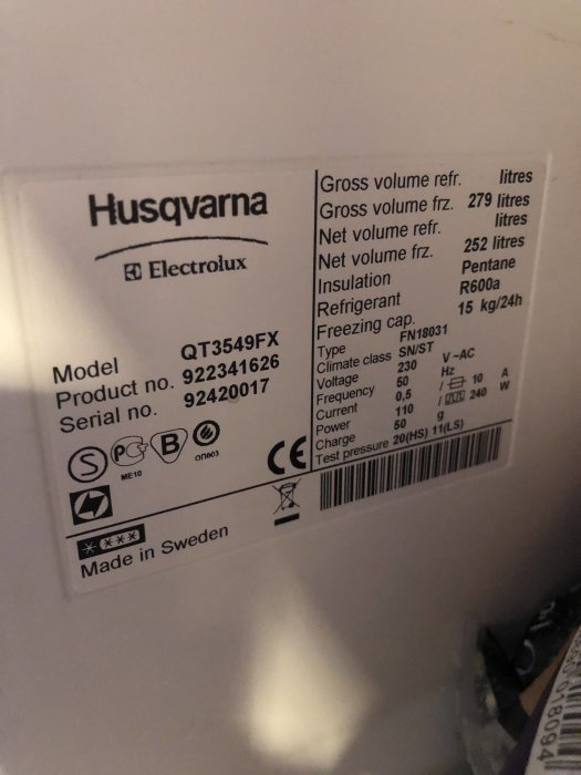 Typskylt på en Husqvarna/Electrolux-kyl med modellbeteckning, serienummer och tekniska specifikationer.