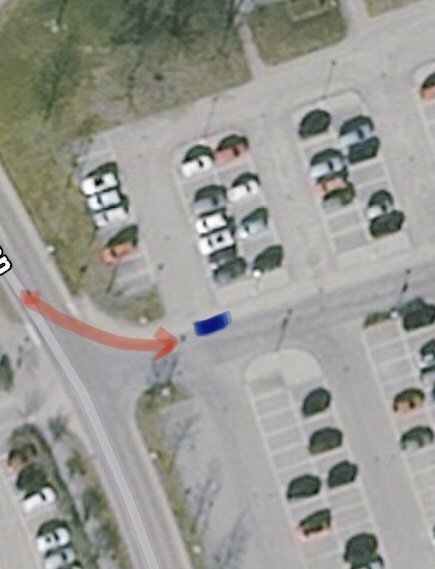 Satellitbild av en parkering med två markerade pilar som visar rörelseriktningen för två bilar.