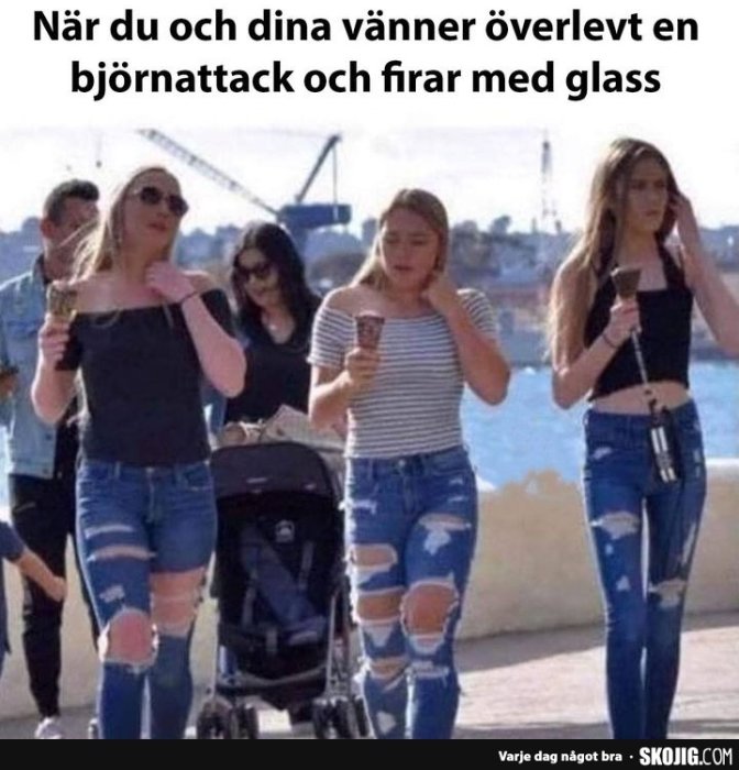 Tre kvinnor som äter glass och går, en kör barnvagn, alla bär slitna jeans.