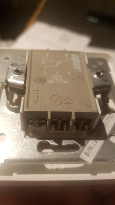 Närbild på en nyinköpt enpolig brytare från Clas Ohlson, omonterad.