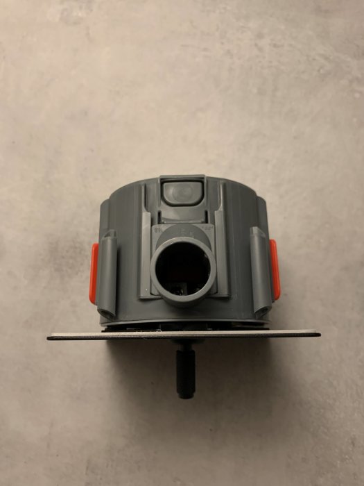 Trappbrytare uppifrån som visar anslutning och monteringselement mot en ljus bakgrund.