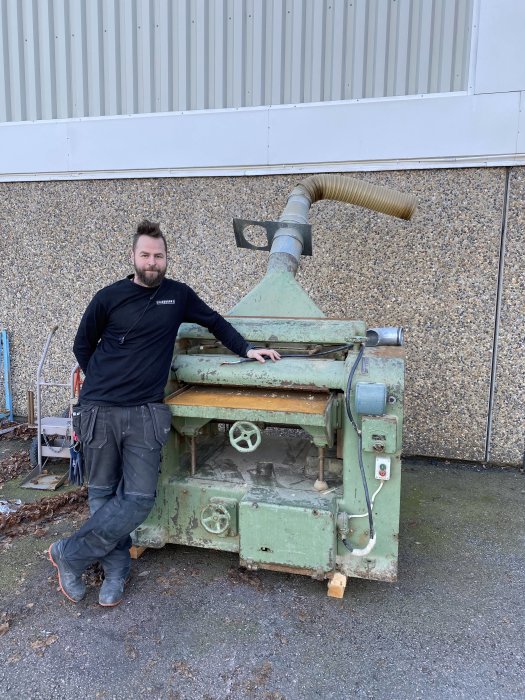 Man lutar sig mot en stor gammal Jonsered planhyvel som tar 800mm breda material.