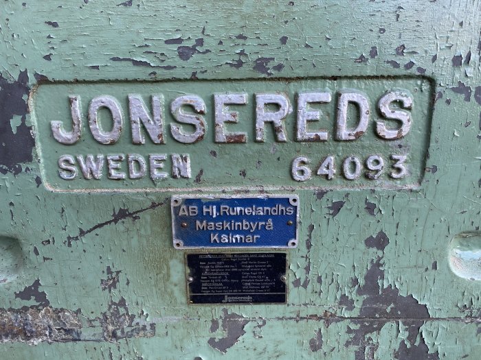 Försliten skylt på en Jonsereds planhyvel, modellnummer 64093, med flagnande grön färg och informationsetikett.