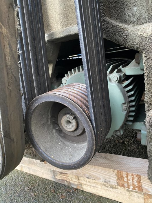 Närbild på en sliten remskiva och drivremmar på en Jonsered planhyvel som kan hantera material upp till 800mm brett.