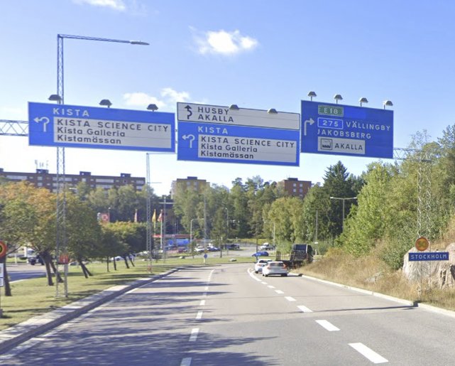 Vägskyltar över rondell vid norra infarten till Kista, bilar på vägen, förvirrande körfält.