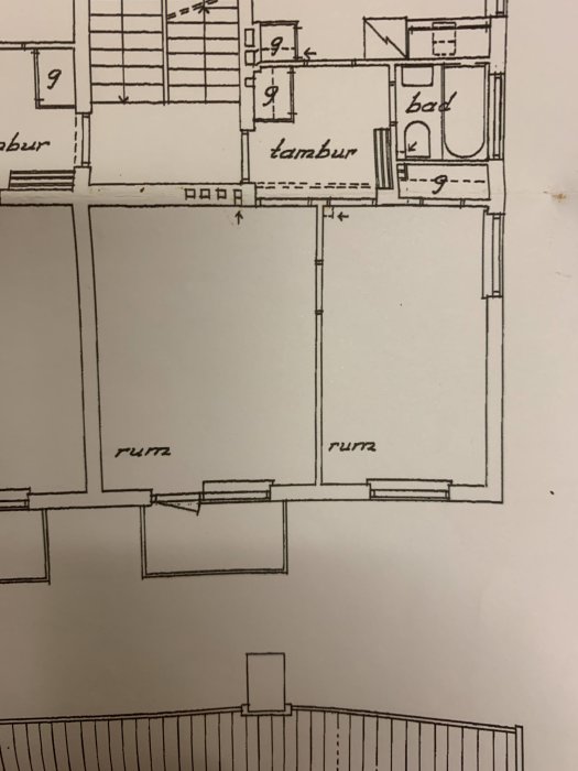 Ritning av en bostadslägenhet med betecknade rum som kök, bad, och tambur.