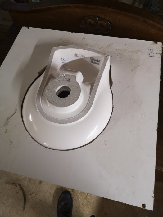Äggformad toalettstol på vit botten, illustrerar en del av ett byggprojekt.
