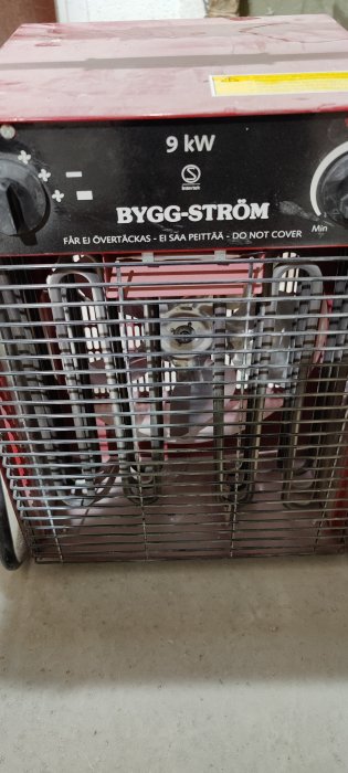 Värmefläkt märkt "BYGG-STRÖM 9 kW" med en varningslapp och inställningsreglage, efter strömavbrott.
