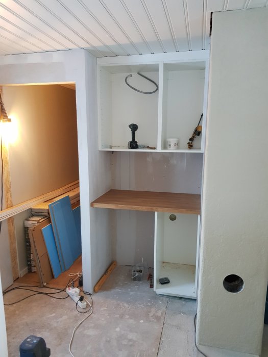 Installation av bänkskåp och bänkskiva med utrymme under för kylskåp i pågående renovering.