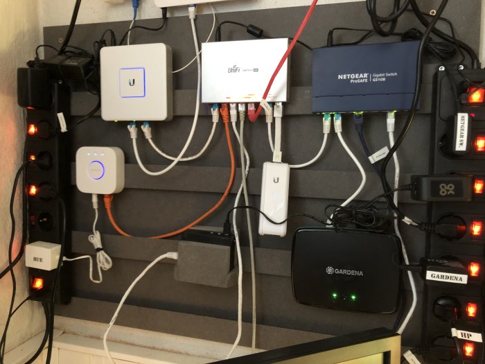 Väggmonterat fransk klyvsystem med router, strömbrytare och nätverksutrustning.