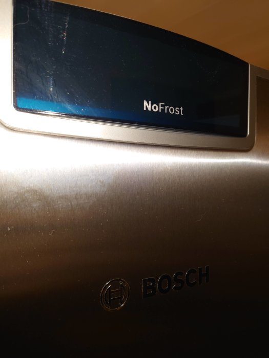 Närbild på en BOSCH kyl/frys med NoFrost-teknik logotyp.