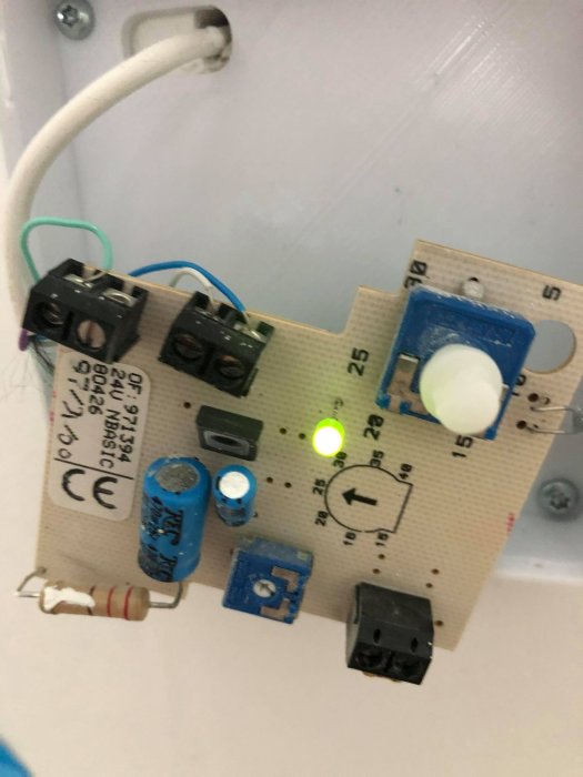 En kretskortskomponent med lysande grön lysdiod och elektriska komponenter såsom kondensatorer och reläer.