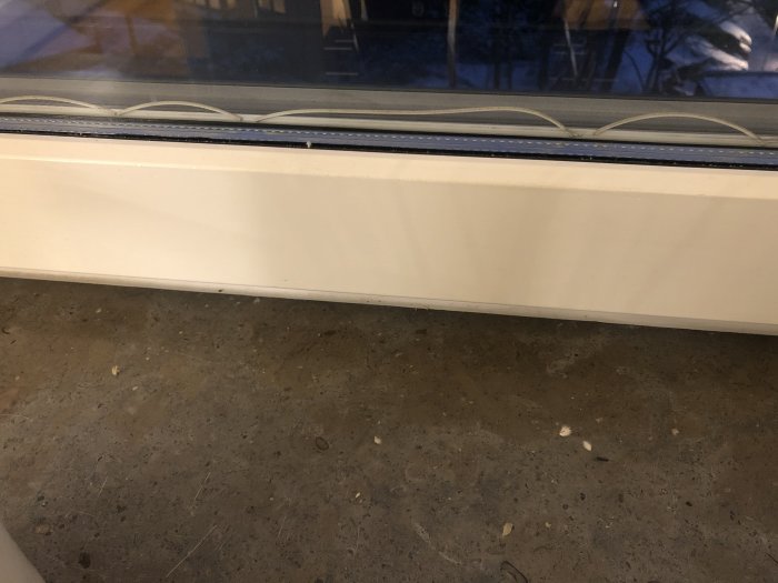 Inomhusvy av ett fönster där tätningen mellan fönsterglasen verkar ha släppt, synlig spricka och luckrum.