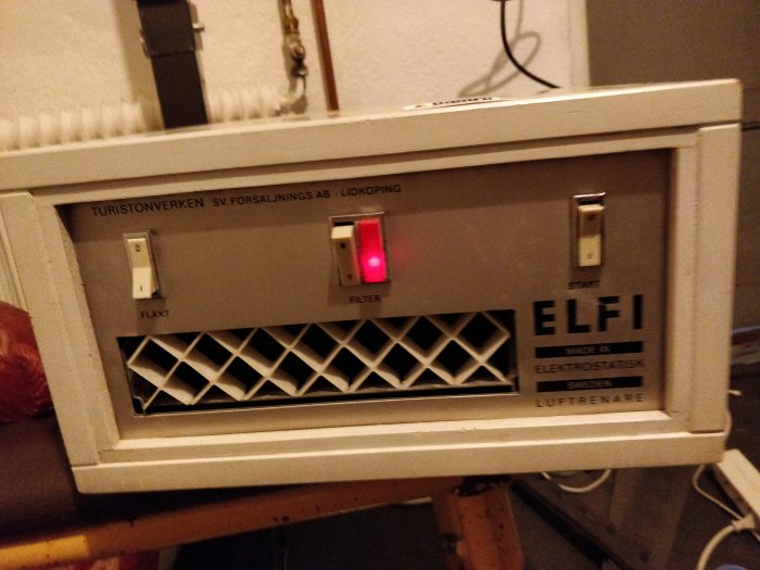 En elektrostatisk luftrenare från ELF med tänd röd lampa märkt "FILTER".