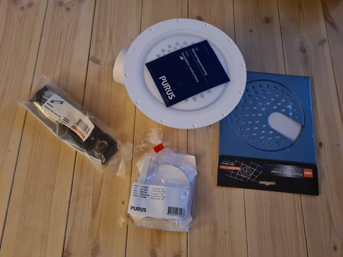 Byggmaterial på trägolv: Damixa blandarfäste, Purus golvbrunn, Puruskniven, QuickNet golvvärme-kit.