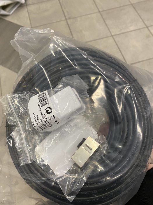 Rulle med 50 meter elektrisk kabel i förpackning och en kabelkontakt.