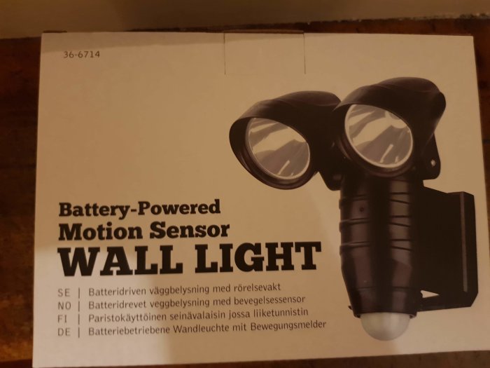 Kartong för batteridriven rörelsesensorlampa som ser ut som en komisk ansiktskarikatyr när den vänds upp och ner.