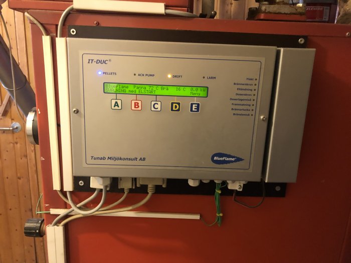 Styrpanel för pelletsbrännare med LED-indikatorer och finsk text från Tunab Miljökonsult AB.