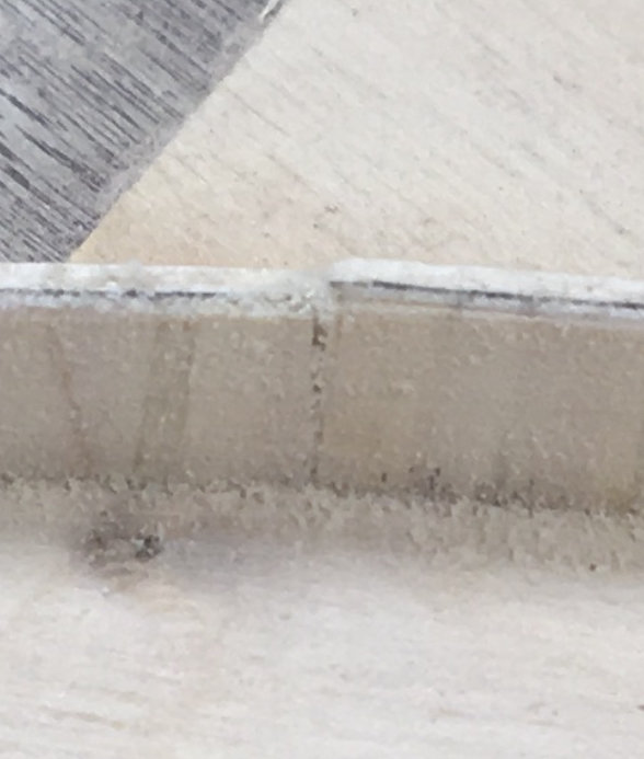 Närbild på en 7 mm hög träkant som behöver sågas för en tät fog.
