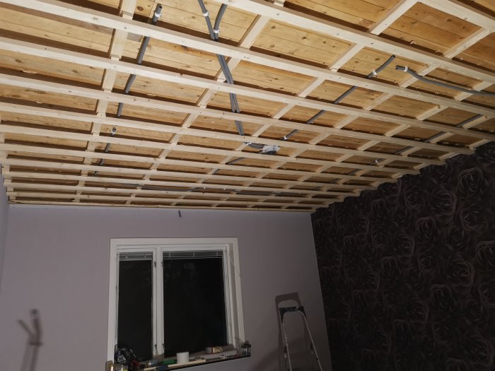 Flexslang installerad i träreglar på ett sovrumstak under konstruktion med huntonittak börjat monteras.
