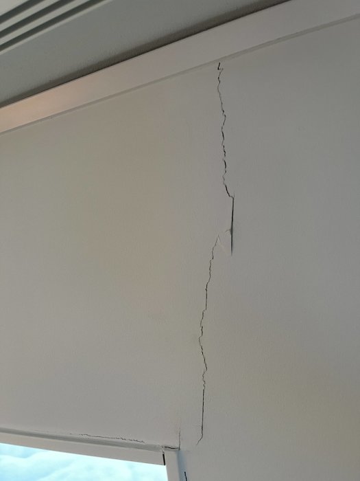 Vertikal spricka i vägg vid fönsterkarm i nybyggt hus.