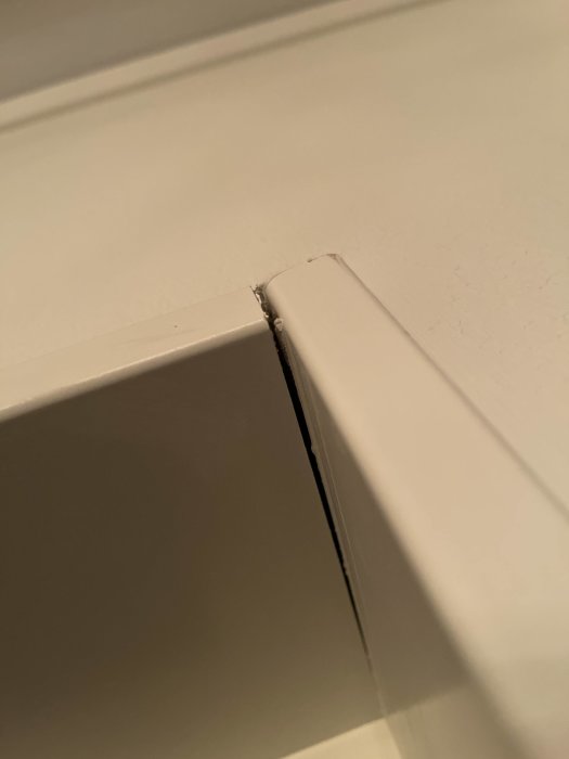 Spricka där två vita lister möts i ett hörn i ett troligen nybyggt hus.