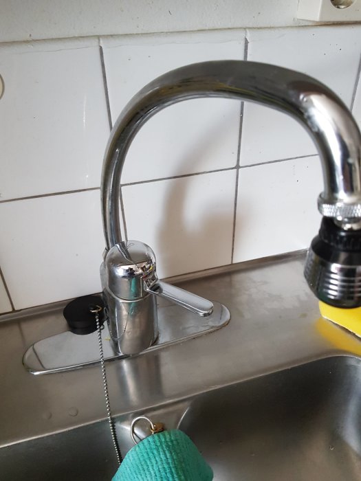 Köksblandare med svårmanövrerad kran monterad i diskho, i behov av åtdragning.