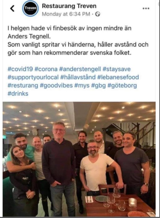 Grupp människor samlade inne på en restaurang, leende mot kameran, med inläggets text synlig ovanför.