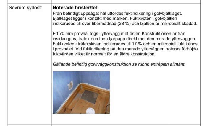 Hörn av ett rum med trägolv och blå väggar där ett golvbrunnstest pågår, med avlägsnat golvsegment och synliga rör.