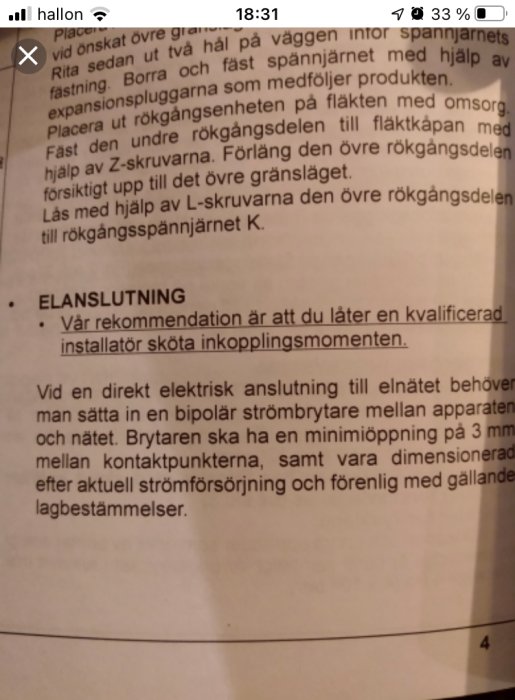 Närbild på en installationsanvisning med text om elanslutning och rekommendation om användning av bipolär strömbrytare.