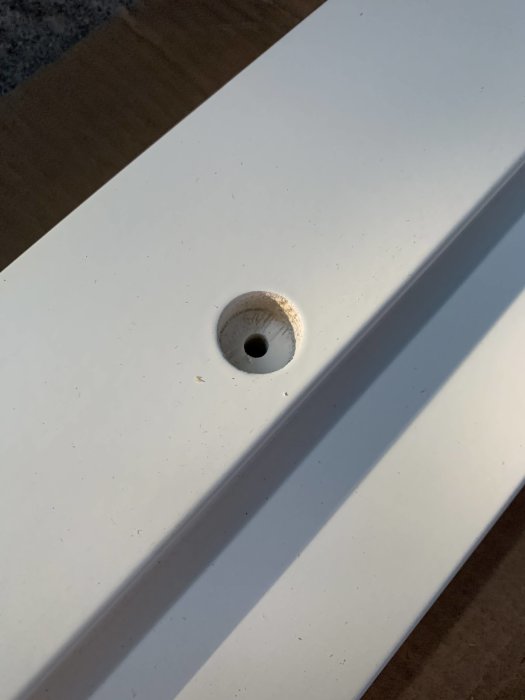 Oöppnad förborrad hål i vit dörrkarm för installation av ytterdörr.