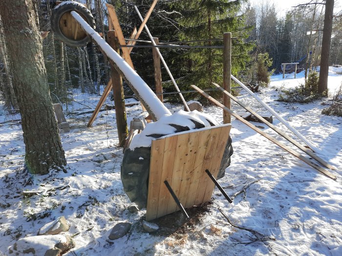 Hemmagjord träningsstation med fasta handtag och stång i ett snötäckt utomhusområde.