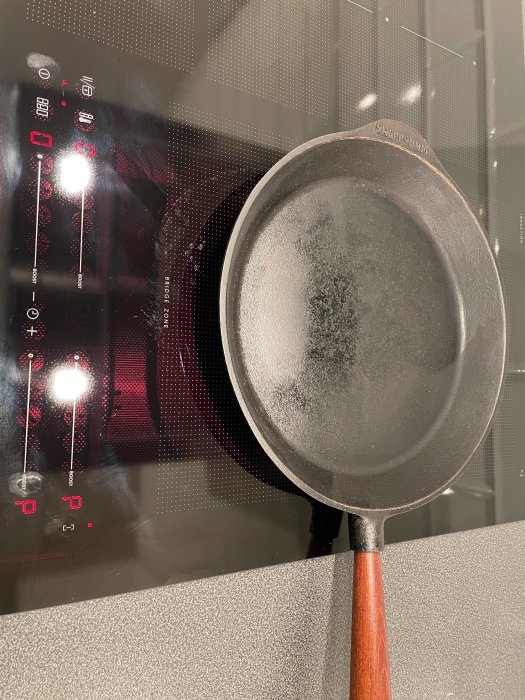 Stekpanna på induktionshäll, med botten som inte täcker båda värmekällorna korrekt.