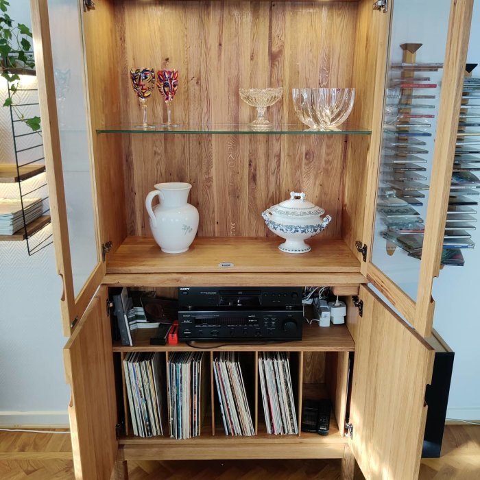 Handgjort skåp i massiv ek med öppna dörrar, innehåller glas, stereo och vinylskivor.