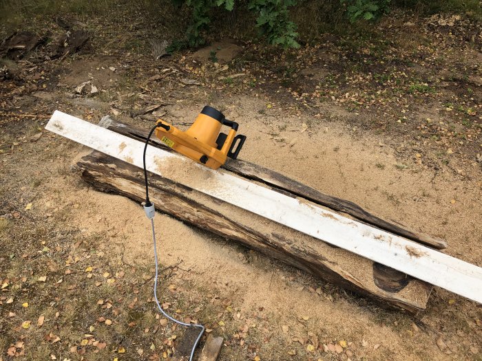 Elektrisk kedjesåg på en trästock i förberedelse för att såga en bänk.