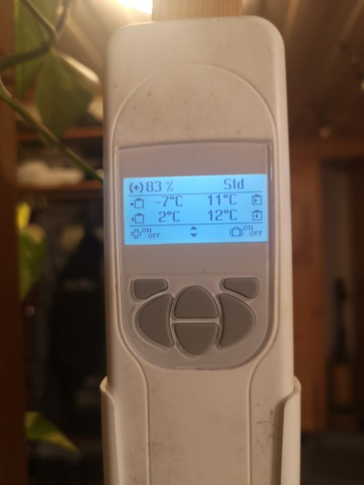 Närbild av en Heru 100 fjärrkontroll med temperaturdisplay som visar -7°C och 11°C utan tillskottsvärme.