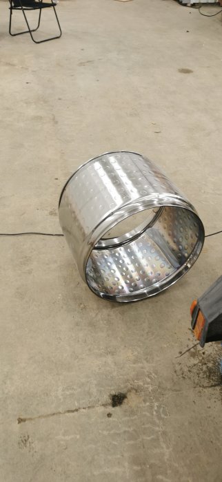 Tumlarens kondensor/förångare demonterad och rengjord, liggande på ett garagegolv.