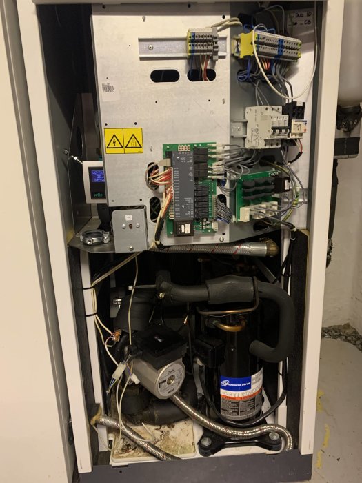 Interiör av öppen Thermia Duo 10 värmepump med synliga elektriska komponenter och rörledningar.