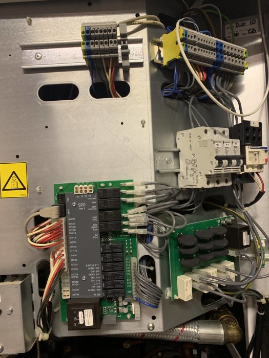Interiör av en Thermia Duo 10 värmepump med öppen panel som visar kablage, säkringar och kretskort.
