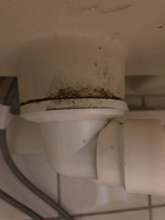 Avloppsrör under handfat med potentiell läckpunkt vid mynningen, röret ser lite förflyttbart ut.