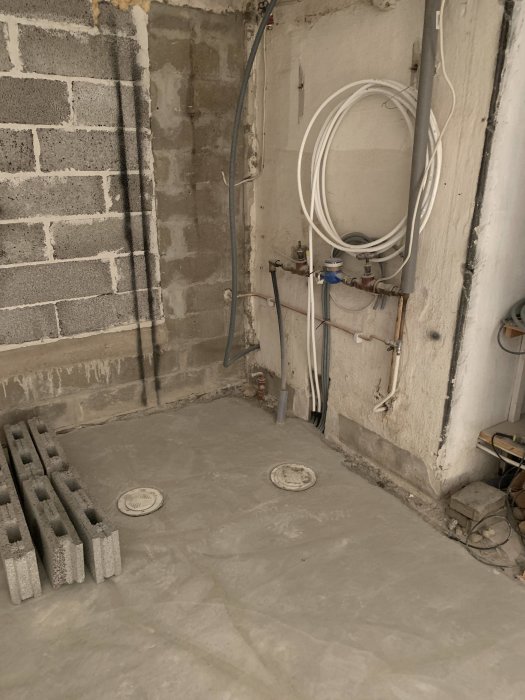 Nyrenoverad rumshörna med betongväggar, elinstallationer samt rördragningar.