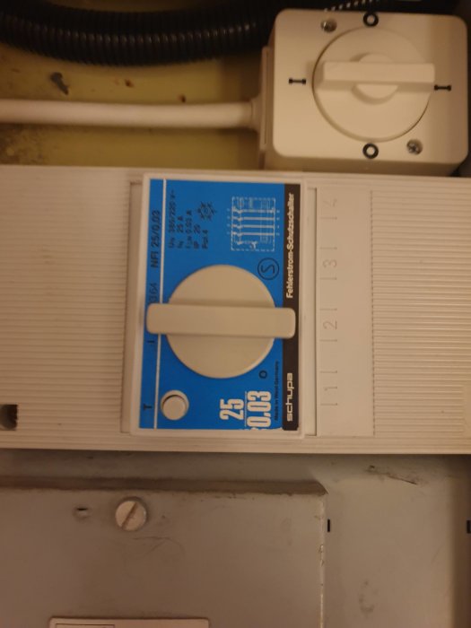 Elektriskt säkringsskåp med en 20A huvudsäkring och ledningar i bakgrunden.