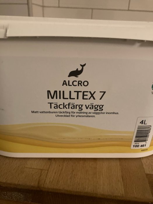 Hink med ALCRO MILLTEX 7 Täckfärg Vägg mot en kakelvägg.