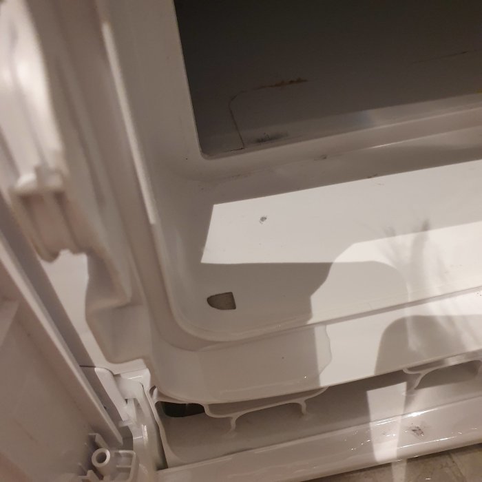 Läckage på framsidan av en vit Cylinda torktumlare där vattendroppar syns på maskinens underdel.