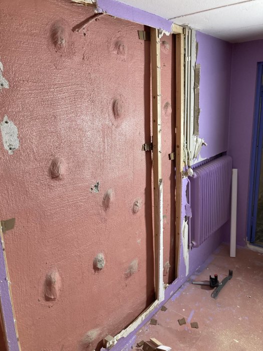 Renoveringsarbete i källare med slipade väggar och påbörjad klinkersläggning, spacklade väggar och demonterade dörrkarmar.