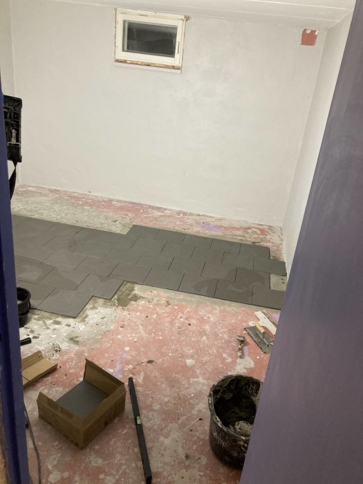 Renovering av källargolv med pågående klinkersläggning och nyslipade samt putsade väggar.